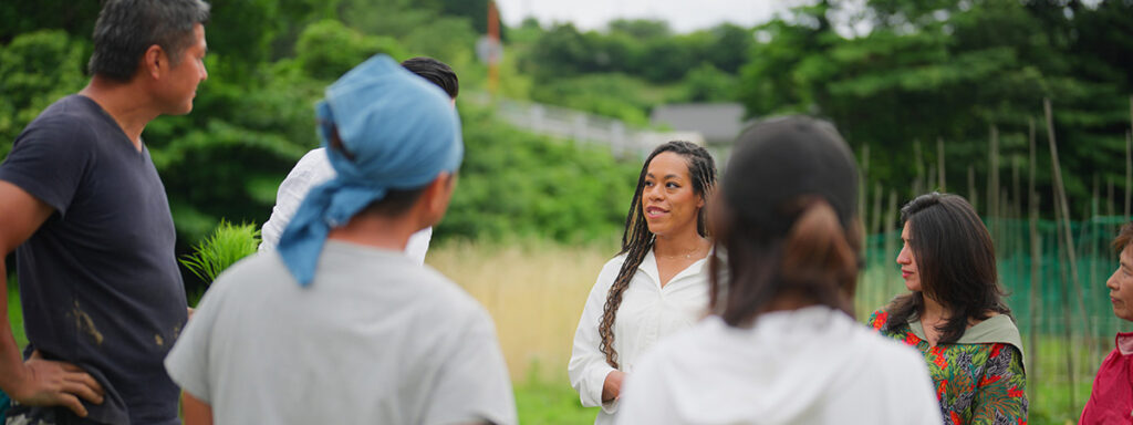 Community engagement researchers converse with migrant farmers in a field